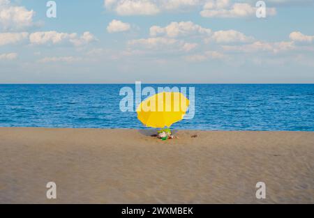 Einsame gelbe Sonnenschirm am Strand von Cristolu Axedu (Sardinien, Italien) Stockfoto