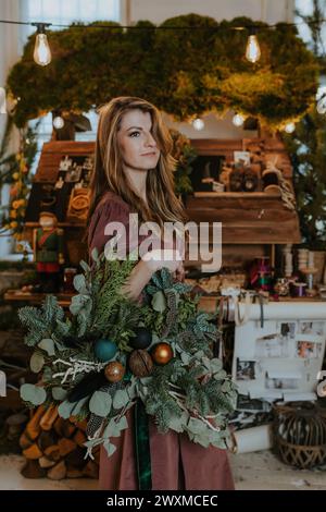 Frau hält einen Weihnachtskranz Stockfoto