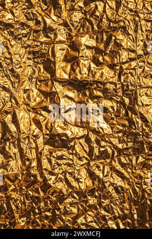 Zerknitterte goldfarbene Aluminium-Zinnfolie als Hintergrund, Draufsicht Stockfoto