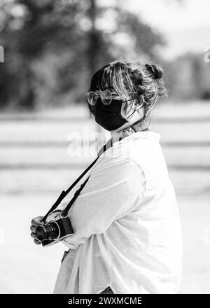 Asiatische Frau mit Brille und Kamera um den Hals Stockfoto