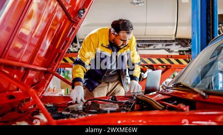 Ein männlicher Arbeiter repariert ein Auto in einer Garage Stockfoto