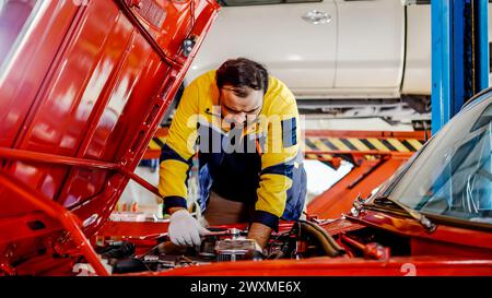 Ein männlicher Arbeiter repariert ein Auto in einer Garage Stockfoto