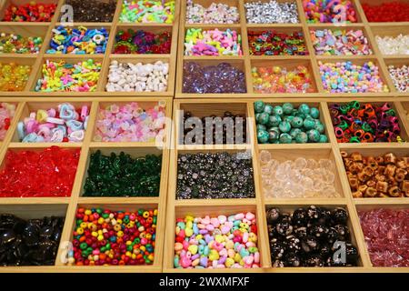 Verschiedene Farben und Formen von Perlen in Holzfächern für Heimwerkerzubehör Stockfoto
