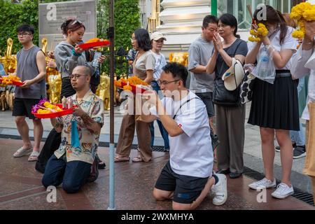 28. März 2024, Bangkok, Thailand: Ein asiatischer Mann betet mit einem Opferkorb, umgeben von der Menge, am Erawan-Schrein in der Innenstadt von Bangkok. Der Erawan-Schrein, der dem Brahma-Gott gewidmet ist, ist ein verehrter Ort, an dem Besucher aus Thailand und rund um den Globus Weihrauch, Girlanden, Früchte und Elefantenstatuen anbieten, in der Hoffnung, dass ihre Wünsche wahr werden. Darüber hinaus trägt der Schrein zu wohltätigen Zwecken bei und unterstützt Krankenhäuser und Organisationen in ganz Thailand. (Credit Image: © Nathalie Jamois/SOPA Images via ZUMA Press Wire) NUR REDAKTIONELLE VERWENDUNG! Nicht für kommerzielle U Stockfoto