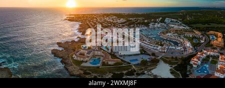 Blick von der Drohne auf den Hafen, die Wohnung und den Strand von Cala en Bosc auf der spanischen Insel Menorca. Stockfoto