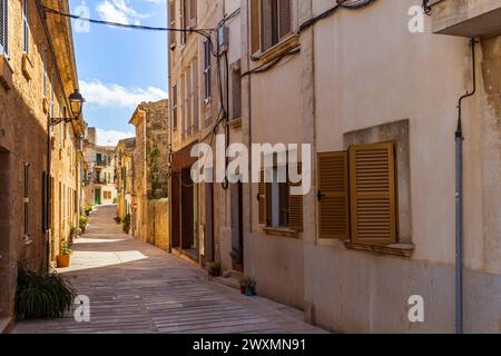 Enge Straße gesäumt von Pflanztöpfen in Alcudia Altstadt, Mallorca, Spanien, Balearen Inseln Stockfoto