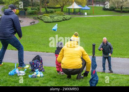 Preston, Lancashire. Wetter in Großbritannien. April 2024. Nasse, rutschige Bedingungen, aber der Regen dämpft keine Geister für Eierrollen. Eine große Ostertradition, die über 150 Jahre zurückreicht, findet am Ostermontag im Avenham and Miller Park in Preston statt. Credit; MediaWorldImages/AlamyLiveNews Stockfoto