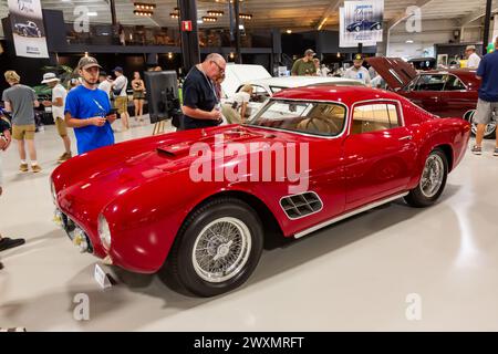 Ein Mann inspiziert ein rotes 1958 Ferrari 250 GT LWB Berlinetta Coupé, das auf der Auburn Auction 2022 der Worldwide Auctioneers in Auburn, Indiana, USA ausgestellt wird. Stockfoto