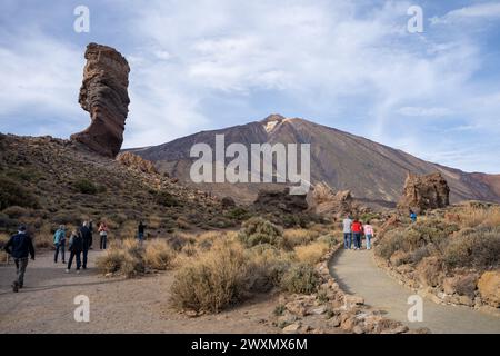 Teneriffa, Spanien - 04.12.2023: Touristen im Roque Cinchado mit Teide im Hintergrund im Teide Nationalpark, Kanarische Inseln Stockfoto