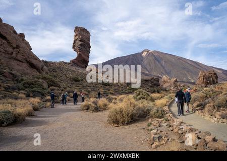 Teneriffa, Spanien - 04.12.2023: Touristen im Roque Cinchado mit Teide im Hintergrund im Teide Nationalpark, Kanarische Inseln Stockfoto