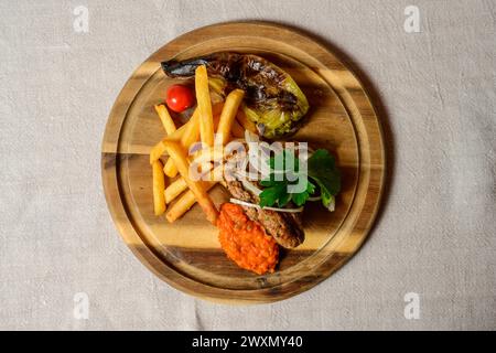 Cevapcici Fleischbällchen im Balkan-Stil mit Ajvar-Sauce, Zwiebeln, Petersilie, Pommes frites und gegrilltem Pfeffer Stockfoto