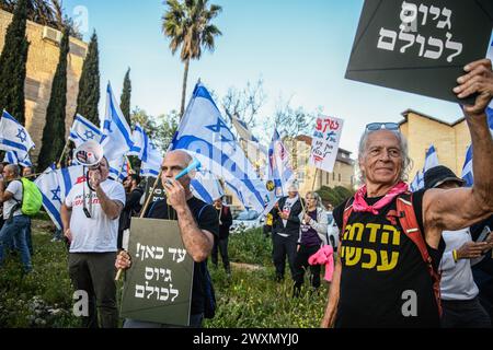 Jerusalem, Israel. April 2024. Demonstranten halten israelische Fahnen und Schilder mit der Aufschrift "das war's! Jeder sollte sich anmelden.“ Israelische Demonstranten, die sofortige allgemeine Wahlen, einen Geiselvertrag und die orthodoxe Rekrutierung für die IDF forderten, demonstrierten vor dem Haus von Aryeh Deri, dem Vorsitzenden der Haredi-Shas-Partei. Quelle: SOPA Images Limited/Alamy Live News Stockfoto