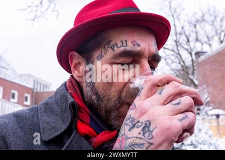 Portrait man in Cold Tilburg, Niederlande. StreetPorträt eines tätowierten Mannes, der einen Hut trägt, während seines ersten Schnees des Jahres durch die Stadt schlendert. Tilburg Steck, hoek Tuinstraat / Nieuwla Noord-Brabant Nederland Copyright: XGuidoxKoppesxPhotox Stockfoto