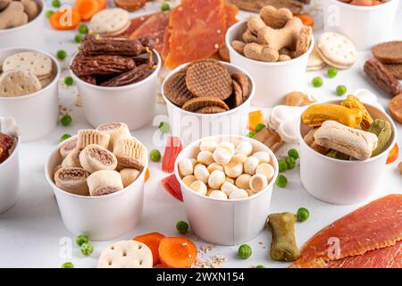 Gesunde Snacks, Hundetraining Leckereien. Auswahl an Snacks für Haustiere, Hundekekse Knochen mit Gemüse und Müsli, verschiedene getrocknete Fleisch- und Schlachtnebenerzeugnisse Stockfoto