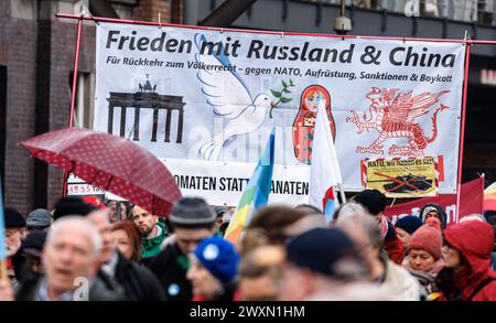 Hamburg, Deutschland. April 2024. Die Menschen nehmen am Hamburger ostermarsch Teil. Ein Banner lautet: "Frieden mit Russland und China. Für eine Rückkehr zum Völkerrecht - gegen NATO-Wiederbewaffnung, Sanktionen und Boykott". Quelle: Markus Scholz/dpa/Alamy Live News Stockfoto