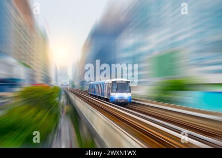 E-Bahnwagen fahren entlang der Route Skyroad Viadukt zwischen modernen Stadtgebäuden und Wolkenkratzern. Konzept moderner verfügbarer Kombi Stockfoto