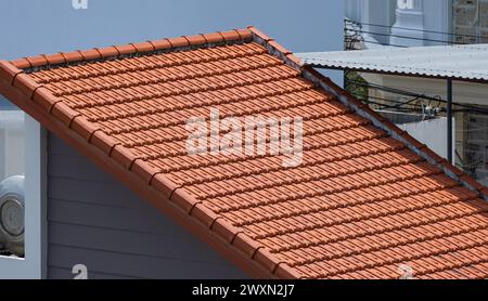 Terrakottadach mit Keramikfliesen auf altem Haus. Nahaufnahme der Dachziegel. Elemente des Terrakotta-Tondachs. Tonziegeldächer Stockfoto