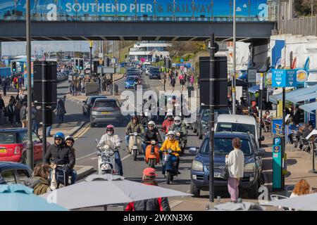 Southend on Sea, Großbritannien. April 2024. Eine geschäftige Straßenszene in der Nähe von Southend Pier and Railway in Southend-on-Sea, Essex, Großbritannien. Das Bild zeigt eine lebhafte Mischung aus Motorradfahrern, Motorrollern, Autos und Fußgängern, die durch die städtische Küstenlandschaft navigieren. Cafés und Geschäfte säumen die Straße, und die Gäste können im Freien sitzen. Die Beschilderung über der Decke markiert den Eingang zum Pier und zum Bahnhof. Obwohl die offizielle Shakedown-Tour in diesem Jahr abgesagt wurde, fahren Motorradfahrer zu einer inoffiziellen Veranstaltung an die Küste. Penelope Barritt/Alamy Live News Stockfoto