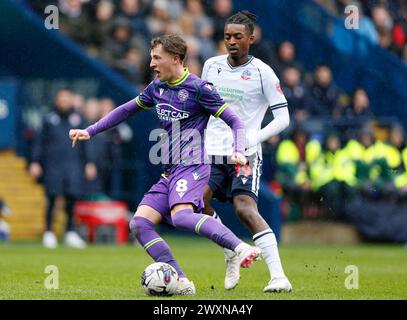 Charlie Savage von Reading (links) in Aktion mit Paris Maghoma von Bolton Wanderers während des Spiels der Sky Bet League One im Toughsheet Community Stadium in Bolton. Bilddatum: Montag, 1. April 2024. Stockfoto