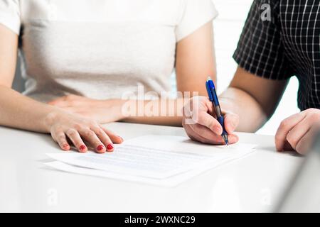 Scheidungsvereinbarung. Ein Paar unterzeichnet ein rechtliches Dokument. Ehevertrag, Ehevertrag. Anwaltsversammlung. Trennung, Trennung oder Klage. Stockfoto