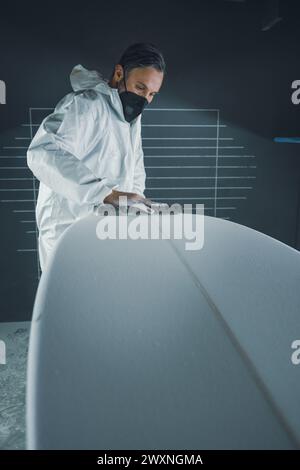 Surfboard-Herstellung, Shaper an Bord Details. Begriff der industriellen Fertigung, qualifizierter Beruf, Beruf und Beschäftigung. Stockfoto