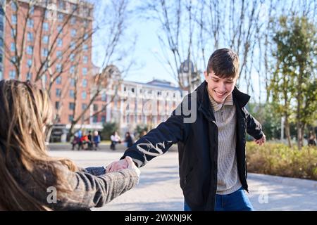 Eine junge Frau, die am Arm ihres Freundes zieht. Ein junges Paar genießt ihre Romantik. Stockfoto