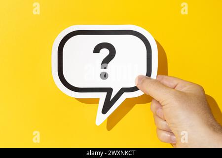 Hand mit Fragezeichen auf der Sprechblase auf gelbem Hintergrund. Zweifel, Verwirrung, Ungewissheit Stockfoto