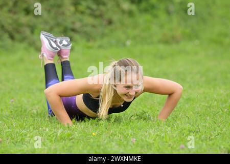 Junge Frau beim Training auf einer Wiese Stockfoto