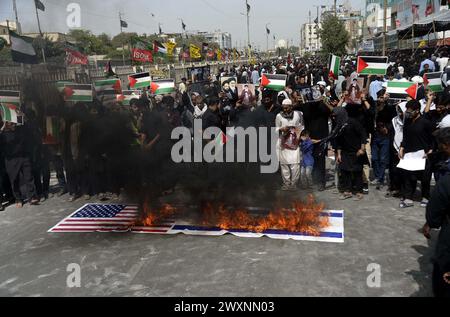 Schiitische Muslime, die Hazrat Ali Al-Murtaza (A.S) trauern, verbrennen die Flagge der USA und Israels, während sie gegen israelische grausame und unmenschliche Handlungen protestieren und die Einheit mit dem unschuldigen Volk Palästinas zum Ausdruck bringen, nachdem sie Salat-e-Zohrain anlässlich des Youm-e-Ali (A.S), dem Tag des Martyriums 21. Ramadan-ul-Mubarak, durchgeführt haben, an der M.A Jinnah Road in Karachi am Montag, 1. April 2024. Stockfoto