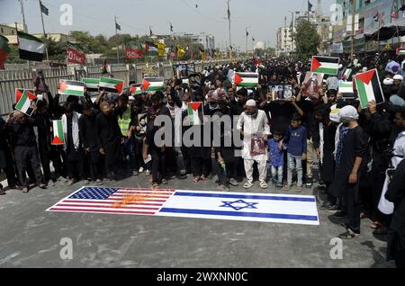 Schiitische Muslime, die Hazrat Ali Al-Murtaza (A.S) trauern, verbrennen die Flagge der USA und Israels, während sie gegen israelische grausame und unmenschliche Handlungen protestieren und die Einheit mit dem unschuldigen Volk Palästinas zum Ausdruck bringen, nachdem sie Salat-e-Zohrain anlässlich des Youm-e-Ali (A.S), dem Tag des Martyriums 21. Ramadan-ul-Mubarak, durchgeführt haben, an der M.A Jinnah Road in Karachi am Montag, 1. April 2024. Stockfoto