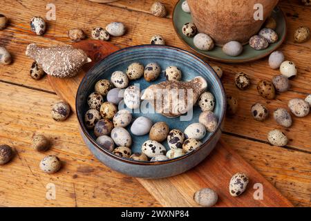 Eine lebendige Ausstellung von natürlichen Wachteleiern auf einer rustikalen Holzoberfläche. Stockfoto