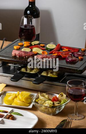 schweizer Raclette mit Fleisch und Gemüse Stockfoto