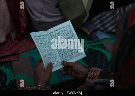 Srinagar, Indien. April 2024. 1. April 2024, Srinagar, Indien: Eine Frau rezitiert aus dem heiligen Koran während des Todestages von Hazrat Ali, Cousin des Propheten Muhammad (pbuh), am Hazratbal-Schrein in Srinagar. Am 1. April 2024 in Srinagar, Indien. (Foto von Firdous Nazir/Eyepix Group) Credit: SIPA USA/Alamy Live News Stockfoto