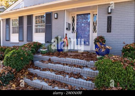 Veranda und Treppe des Hauses tief mit Herbstlaub bedeckt, Hauspflege Blatt sauber, horizontaler Aspekt Stockfoto