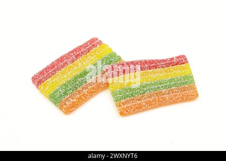 Regenbogenstreifen Zuckerkristalle bestreute Gummigelee Bonbons isoliert auf weißem Hintergrund Stockfoto