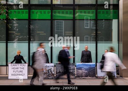 Oktober 2023. Standard Chartered Bank Offices, City of London, UK. Demonstranten der Money Rebellion zeigen eine Ausstellung mit Fotos von Gideon Mendel. Die Pop-up-Ausstellung ist ein Widerspruch zur Standard Chartered Bank, die erneut den Wettbewerb „Wetterfotograf des Jahres“ sponsert. Diese Greenwashing-Übung fängt das dramatische Spektakel extremer Wetterereignisse weltweit ein, lässt aber die Rolle der Bank bei ihrer Entwicklung völlig außer Acht. Oft werden diese fesselnden Schnappschüsse auch nicht in größeren Ruinenszenen kontextualisiert, was darauf hindeutet, dass extremes Wetter schön ist, subli Stockfoto