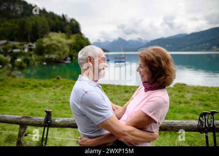 Porträt eines verliebten älteren Ehepaares, das gemeinsam in den Bergen wandert. Senioren-Touristen, die sich umarmen, küssen. Stockfoto