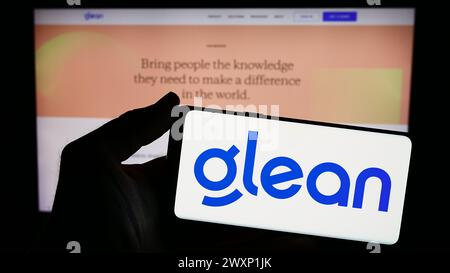 Person, die ein Smartphone mit dem Logo der US-amerikanischen KI-Assistenzfirma GLean Technologies Inc. Vor der Website hält. Schwerpunkt auf dem Display des Telefons. Stockfoto
