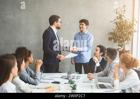 Zwei Geschäftsmänner schütteln sich die Hände bei einem Treffen in einem modernen Büro Stockfoto