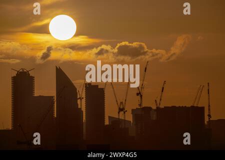 London, Großbritannien. April 2024. Wetter in Großbritannien: Dramatische Abendsonne untergeht über den Gebäuden der Stadt und endet am Ostermontag mit gemischtem Wetter. Guy Corbishley/Alamy Live News Stockfoto