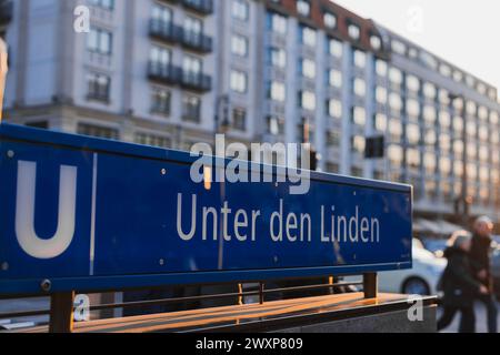 Abendliche Kulisse an der Schautafel der U-Bahn-Station Unten den Linden in Berlin. Einige Leute, die vorbeigingen, wunderschöne, sonnendurchflutete Gebäude sehen Stockfoto