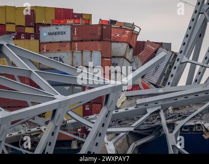 Baltimore, USA. März 2024. Umgestürzte Container sind am Donnerstag, 28. März 2024 in der verdrehten Struktur und dem Straßendeck der Francis Scott Key Bridge zu sehen, die über den Bug des Containerschiffs Dali gezogen sind. Am frühen Morgen des 26. März verlor der Dali die Energie, als er den Hafen von Baltimore verließ und einen Stützpfeiler der Key Bridge traf, was zu einem katastrophalen Ausfall führte. (Foto: Jerry Jackson/The Baltimore Sun/TNS/SIPA USA) Credit: SIPA USA/Alamy Live News Stockfoto