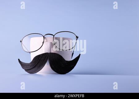 Männergesicht aus künstlichem Schnurrbart, Brille und Tasse auf hellblauem Hintergrund. Leerzeichen für Text Stockfoto