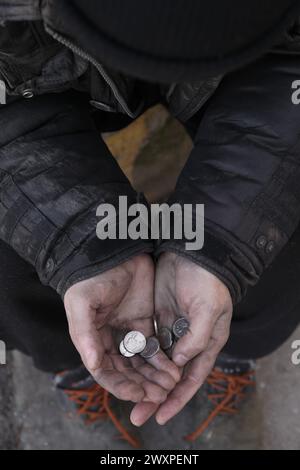 Armer Obdachloser, der draußen Münzen hält, Nahaufnahme Stockfoto