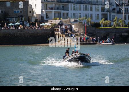 Salcombe nach East Portlemouth Ferry, mittlerer Kanal, mit einem vollen Ferry Pub und Warteschlangen auf der Landung im Hintergrund, ruhiges Wasser. Stockfoto