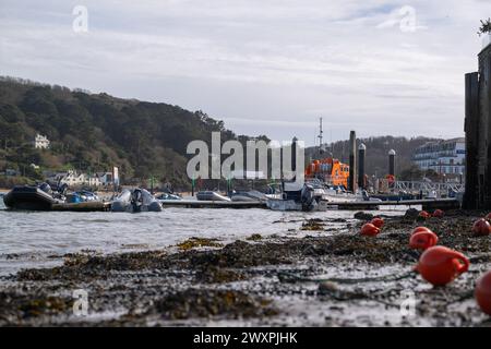 Ebbe am Strand am Victoria Quay, Niedrigwinkelaufnahme mit dem Rettungsboot in der Ferne und Bojen auf Schlamm im Vordergrund Stockfoto