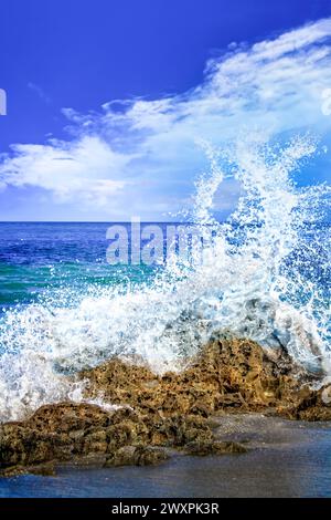 Wellen brechen bei Flut am Blowing Rocks Beach gegen die Felsen. Stockfoto