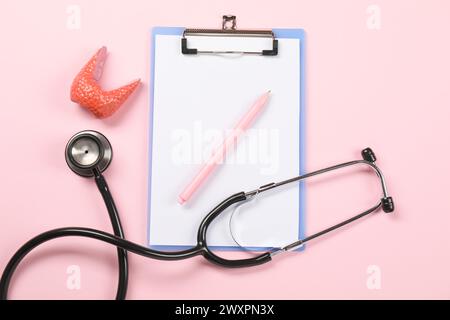 Endokrinologie. Stethoskop, Clipboard, Modell der Schilddrüse und Stift auf rosa Hintergrund, flache Lage Stockfoto