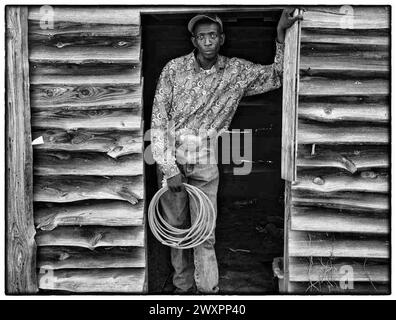 Shelby, North Carolina, USA. August 2023. SHELBY, NORTH CAROLINA: CAROLINA COWBOY mit einem Seil in der Hand in der Arena während des dritten Tages des Ebony Horseman Trail Rides. Mindestens 800 Reiter nehmen an dem Trail-Ritt Teil und über 20 bis 25.000 Zuschauer besuchten die Reiter, Rodeo, Line Dance und Unterstützungsverkäufer. Die Beamten sagten. Die Veranstaltungsfläche ist 20 Hektar groß und bietet Platz für bis zu fünftausend Wohnmobile, Autos und Zelte. Den Teilnehmern wird eine Eintrittsgebühr ab 60 Dollar für die viertägige Veranstaltung berechnet, aber die Reiter sind kostenlos. Die Veranstaltung bietet Platz für eine Arena, einen Gesellschaftsraum und öffentliche Duschen und Stockfoto