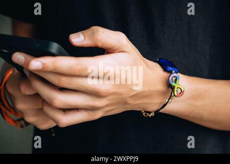 Teenager mit Handgelenk mit Autismus-Infinity-Regenbogensymbol auf der Hand. Welt-Autismus-Bewusstseinstag, Autismus-Rechte-Bewegung, Neurodiversität Stockfoto